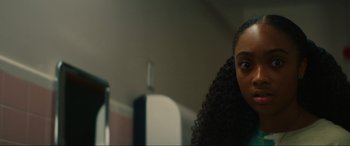 Movie still from “Summering” (2022), directed by James Ponsoldt – A person with long black curly hair; Close Up shot, Over the shoulder angle