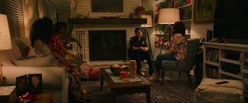 Movie still from “Summering” (2022), directed by James Ponsoldt – Two people sitting in front of a fire place; Wide shot, Over the shoulder angle