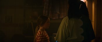Movie still from “Summering” (2022), directed by James Ponsoldt – A young girl standing next to an older man; Medium shot, Over the shoulder angle