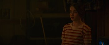 Movie still from “Summering” (2022), directed by James Ponsoldt – A girl in a striped shirt is standing in the dark; Medium shot, Over the shoulder angle