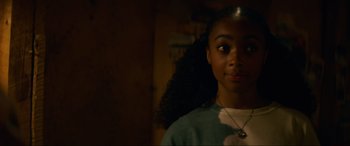Movie still from “Summering” (2022), directed by James Ponsoldt – A young woman with long black curly hair looking at the camera; Close Up shot, Over the shoulder angle