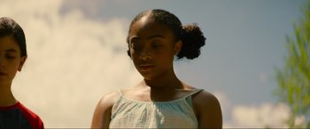 Movie still from “Summering” (2022), directed by James Ponsoldt – A young woman with a bun in a white top; Close Up shot, Low angle