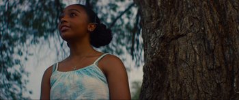 Movie still from “Summering” (2022), directed by James Ponsoldt – A young woman standing in front of a tree; Close Up shot, Low angle