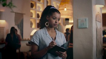 Movie still from “Summertime” (2020), directed by Carlos López Estrada – A woman writing in a notebook while standing in a room; Close Up shot, Over the shoulder angle