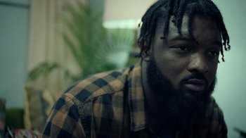 Movie still from “Summertime” (2020), directed by Carlos López Estrada – A person wearing a plaid shirt; Close Up shot, Low angle