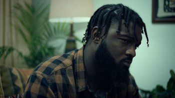 Movie still from “Summertime” (2020), directed by Carlos López Estrada – A person wearing a plaid shirt; Close Up shot, Low angle