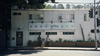 Movie still from “Summertime” (2020), directed by Carlos López Estrada – Two people standing outside of a medical marijuana dispensary; Extreme Wide shot, Low angle
