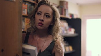 Movie still from “Summertime” (2020), directed by Carlos López Estrada – A beautiful young lady holding a book in a store; Close Up shot, Low angle