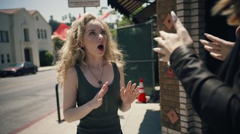 Movie still from “Summertime” (2020), directed by Carlos López Estrada – A woman standing next to a brick wall with her hands up; Close Up shot, Over the shoulder angle