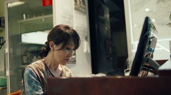 Movie still from “Summertime” (2020), directed by Carlos López Estrada – A woman sitting in front of a laptop computer; Close Up shot, Low angle