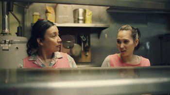 Movie still from “Summertime” (2020), directed by Carlos López Estrada – Two women are talking to each other in a kitchen; Close Up shot, High angle