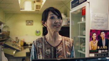 Movie still from “Summertime” (2020), directed by Carlos López Estrada – A woman standing in front of an open refrigerator; Close Up shot, Over the shoulder angle
