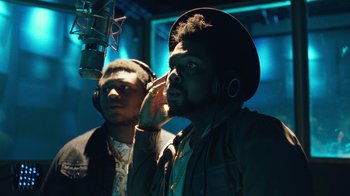 Movie still from “Summertime” (2020), directed by Carlos López Estrada – Two men in a recording studio one of them is listening to headphones; Close Up shot, Low angle