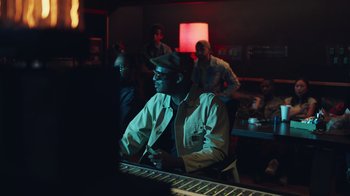 Movie still from “Summertime” (2020), directed by Carlos López Estrada – A man sitting at a keyboard in a room; Medium shot, Over the shoulder angle