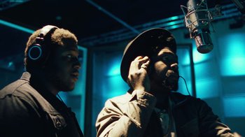 Movie still from “Summertime” (2020), directed by Carlos López Estrada – Two men in a recording studio one of them is wearing a hat; Close Up shot, Low angle