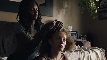 Movie still from “Summertime” (2020), directed by Carlos López Estrada – A woman getting her hair combed by another woman; Close Up shot, Over the shoulder angle