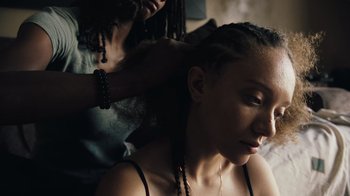 Movie still from “Summertime” (2020), directed by Carlos López Estrada – A woman getting her hair combed by a stylist; Close Up shot, Over the shoulder angle