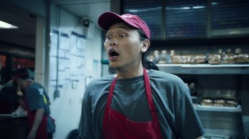 Movie still from “Summertime” (2020), directed by Carlos López Estrada – A man wearing an apron and a red hat is looking surprised; Close Up shot, Low angle