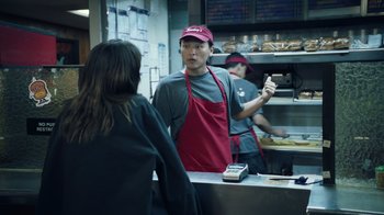 Movie still from “Summertime” (2020), directed by Carlos López Estrada – A man and a woman in a kitchen talking to a customer; Medium shot, Over the shoulder angle