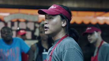 Movie still from “Summertime” (2020), directed by Carlos López Estrada – A man wearing a red hat and a gray shirt; Close Up shot, Low angle