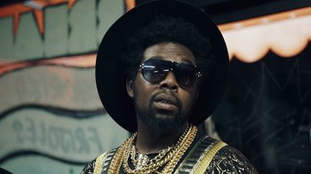 Movie still from “Summertime” (2020), directed by Carlos López Estrada – A person wearing sunglasses and a hat; Close Up shot, Low angle