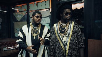 Movie still from “Summertime” (2020), directed by Carlos López Estrada – A couple of men standing next to each other; Medium shot, Low angle