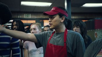 Movie still from “Summertime” (2020), directed by Carlos López Estrada – A group of people standing in a room; Medium shot, Over the shoulder angle