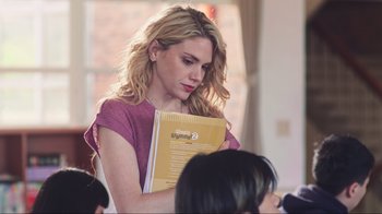 Movie still from “Sun Moon” (2023), directed by Sydney Tooley – A woman is holding a book in her hands; Medium shot, Over the shoulder angle