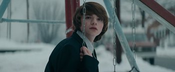 Movie still from “Super 8” (2011), directed by J.J. Abrams – A young boy in a black shirt and white tie; Close Up shot, Low angle