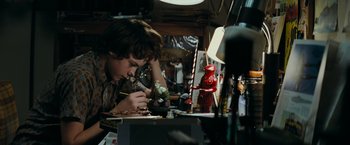 Movie still from “Super 8” (2011), directed by J.J. Abrams – A young boy is painting a toy at a table; Close Up shot, High angle