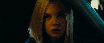 Movie still from “Super 8” (2011), directed by J.J. Abrams – A young woman with long blonde hair stares into the camera; Close Up shot, Low angle