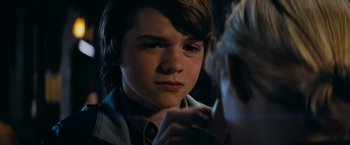 Movie still from “Super 8” (2011), directed by J.J. Abrams – A young boy is looking at the camera; Close Up shot, Over the shoulder angle