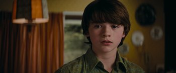 Movie still from “Super 8” (2011), directed by J.J. Abrams – A young boy is looking into the camera; Close Up shot, Low angle