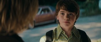 Movie still from “Super 8” (2011), directed by J.J. Abrams – A young boy with a yellow shirt and a backpack; Close Up shot, Over the shoulder angle