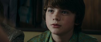 Movie still from “Super 8” (2011), directed by J.J. Abrams – A boy's face in a green shirt; Close Up shot, Over the shoulder angle