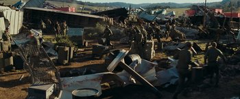 Movie still from “Super 8” (2011), directed by J.J. Abrams – A group of people in a field with a lot of trash; Extreme Wide shot, High angle