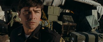 Movie still from “Super 8” (2011), directed by J.J. Abrams – A person wearing a police uniform; Close Up shot, Low angle