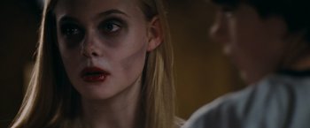Movie still from “Super 8” (2011), directed by J.J. Abrams – A young woman with a bruised face looking into the camera; Close Up shot, Over the shoulder angle