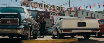 Movie still from “Super 8” (2011), directed by J.J. Abrams – Two people standing on the side of the road near parked cars; Wide shot, Low angle