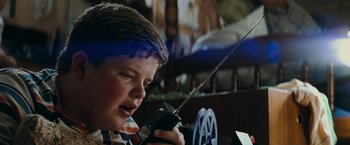Movie still from “Super 8” (2011), directed by J.J. Abrams – A young boy is holding a walkie talkie; Close Up shot, Low angle