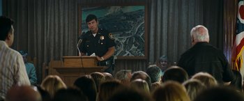 Movie still from “Super 8” (2011), directed by J.J. Abrams – A police officer giving a speech to a crowd of onlookers; Medium shot, Over the shoulder angle