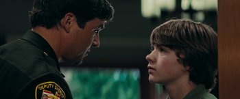 Movie still from “Super 8” (2011), directed by J.J. Abrams – A man and a boy face to face in a room; Close Up shot, Over the shoulder angle