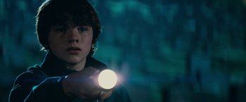Movie still from “Super 8” (2011), directed by J.J. Abrams – A young boy holding a flashlight in the dark; Close Up shot, Low angle