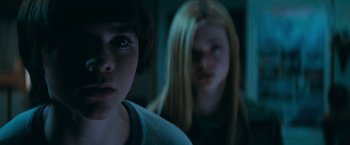 Movie still from “Super 8” (2011), directed by J.J. Abrams – Two young people in a dark room looking at the camera; Close Up shot, Low angle