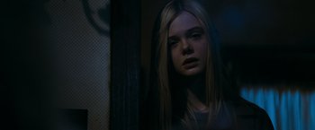 Movie still from “Super 8” (2011), directed by J.J. Abrams – A young woman with long blonde hair looking at the camera; Close Up shot, Low angle