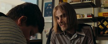 Movie still from “Super 8” (2011), directed by J.J. Abrams – A man with long blonde hair is talking to another man; Close Up shot, Over the shoulder angle