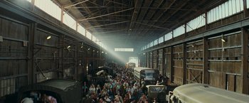 Movie still from “Super 8” (2011), directed by J.J. Abrams – A large group of people are gathered in an old train station; Extreme Wide shot, High angle