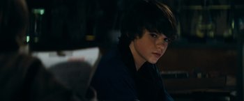 Movie still from “Super 8” (2011), directed by J.J. Abrams – A young man sitting in a dark room; Close Up shot, Over the shoulder angle