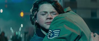Movie still from “Super 8” (2011), directed by J.J. Abrams – A young man in military fatigues hugging a soldier in fatigues; Close Up shot, Over the shoulder angle