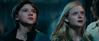Movie still from “Super 8” (2011), directed by J.J. Abrams – Two people standing next to each other in a dark room; Close Up shot, Low angle